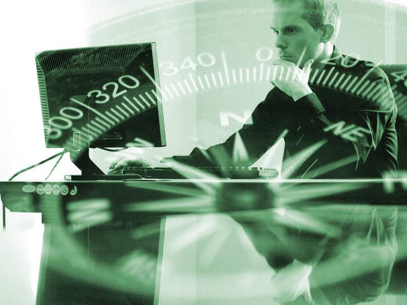 Graphic Designer at desk looking at screen with compass over top of image